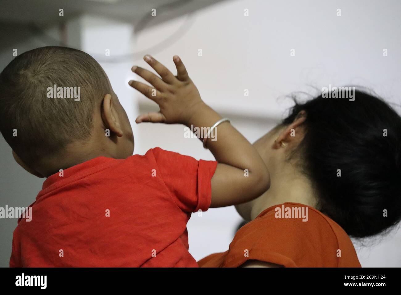 Irritiertes Baby schlappt Mama während Corona Lockdown Stockfoto