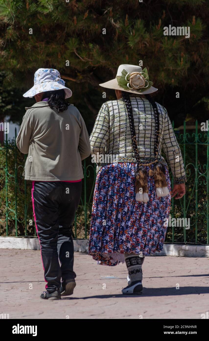 COPACABANA, BOLIVIEN - 24. JULI 2016: Zwei nicht identifizierte bolivianische Frauen gehen um den Platz in Copacabana, Bolivien Stockfoto COPACABANA, BOLIVIEN - 24. JULI 2016: Zwei nicht identifizierte bolivianische Frauen gehen um den Platz in Copacabana, Bolivien Stockfoto