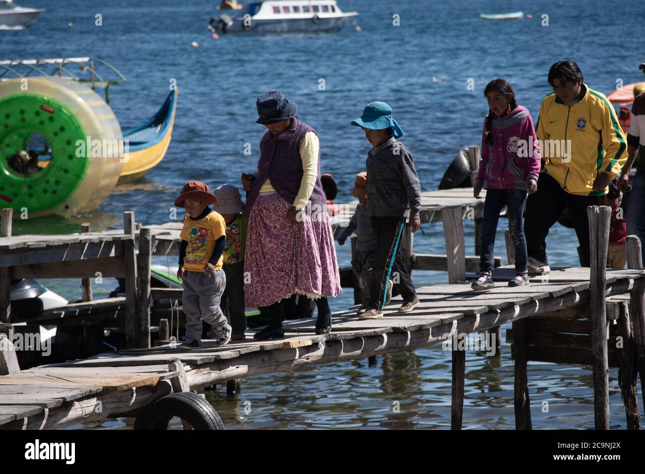 COPACABANA, BOLIVIEN - 24. JULI 2016: Eine bolivianische Familie geht durch einen hölzernen Pier in Copacabana, Bolivien Stockfoto