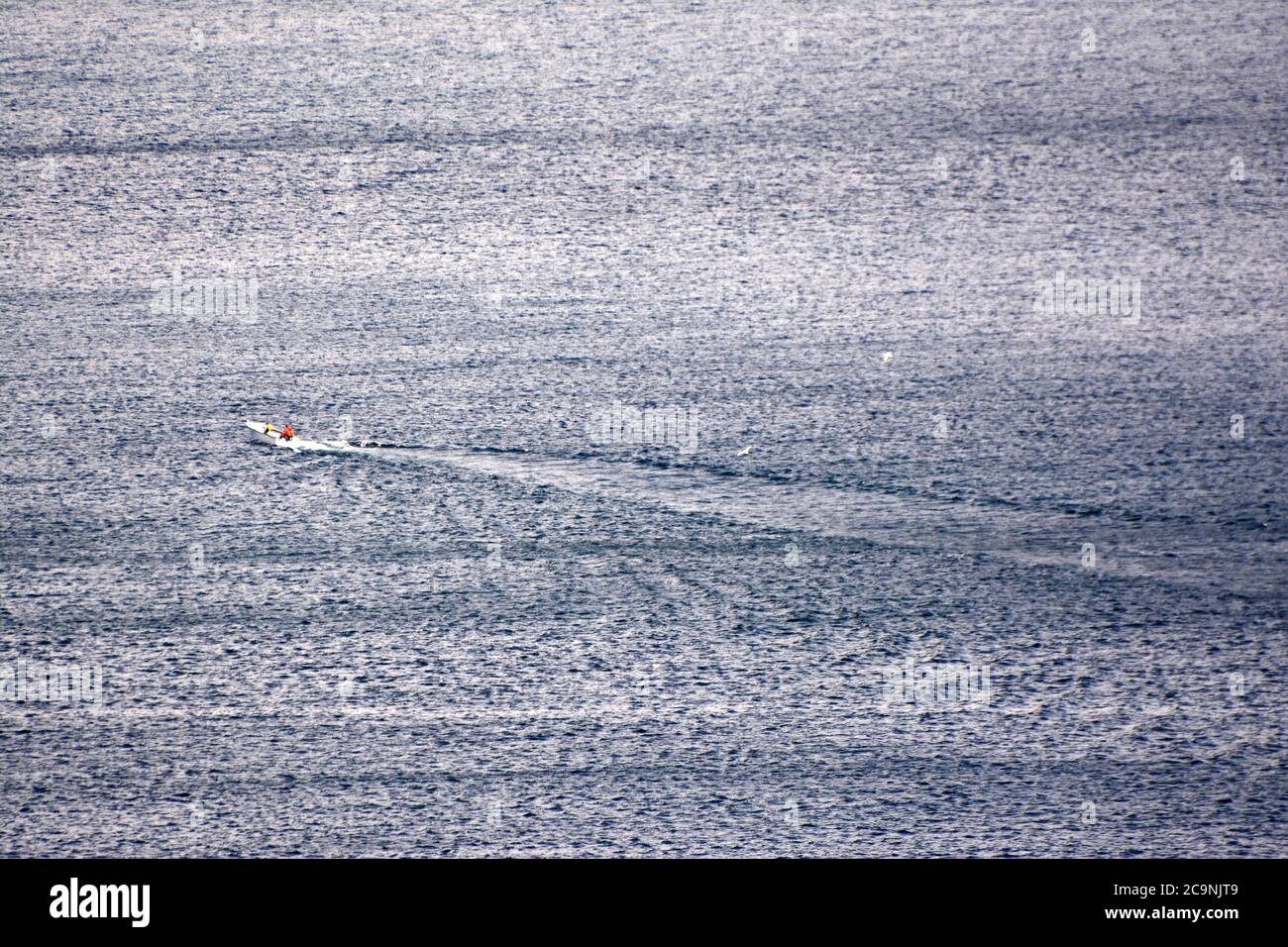 Kleines Boot auf ruhiger flacher Oberfläche des Ozeans Stockfoto