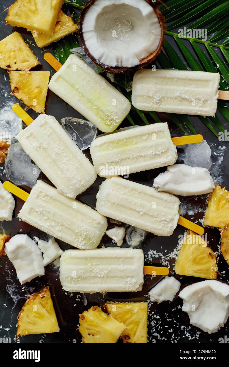 Sommerpopsicles auf Stock. Pinacolada Geschmack. Hergestellt mit Ananas, cocount Milch, Rum. Veganer Snack Stockfoto