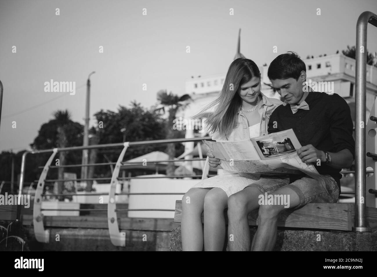 ODESSA, UKRAINE - 06. AUGUST 2015: Nahaufnahme eines glücklichen jungen Paares auf dem Holzdeck im Hafen mit einer Karte in den Händen, Reisekonzept Stockfoto