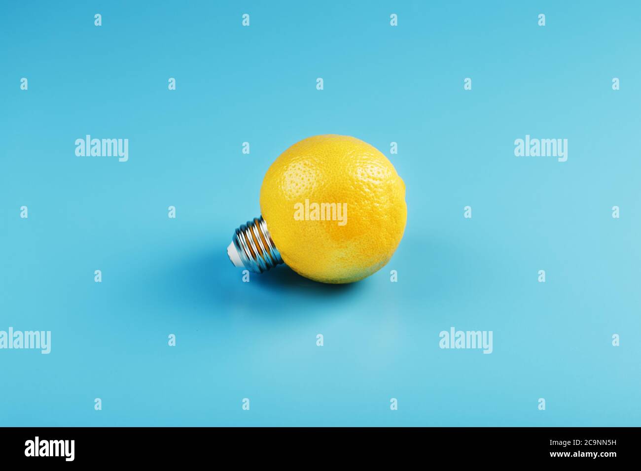 Die Glühbirne ist wie eine Zitrone auf blauem Hintergrund. Stockfoto