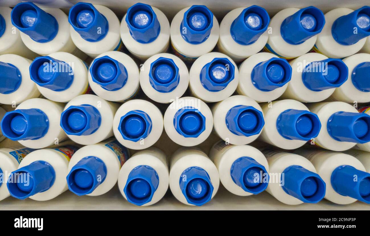 Flaschen mit Kleber im Bürobedarf speichern, weiße Flaschen mit blauer Kappe in einer Box Stockfoto