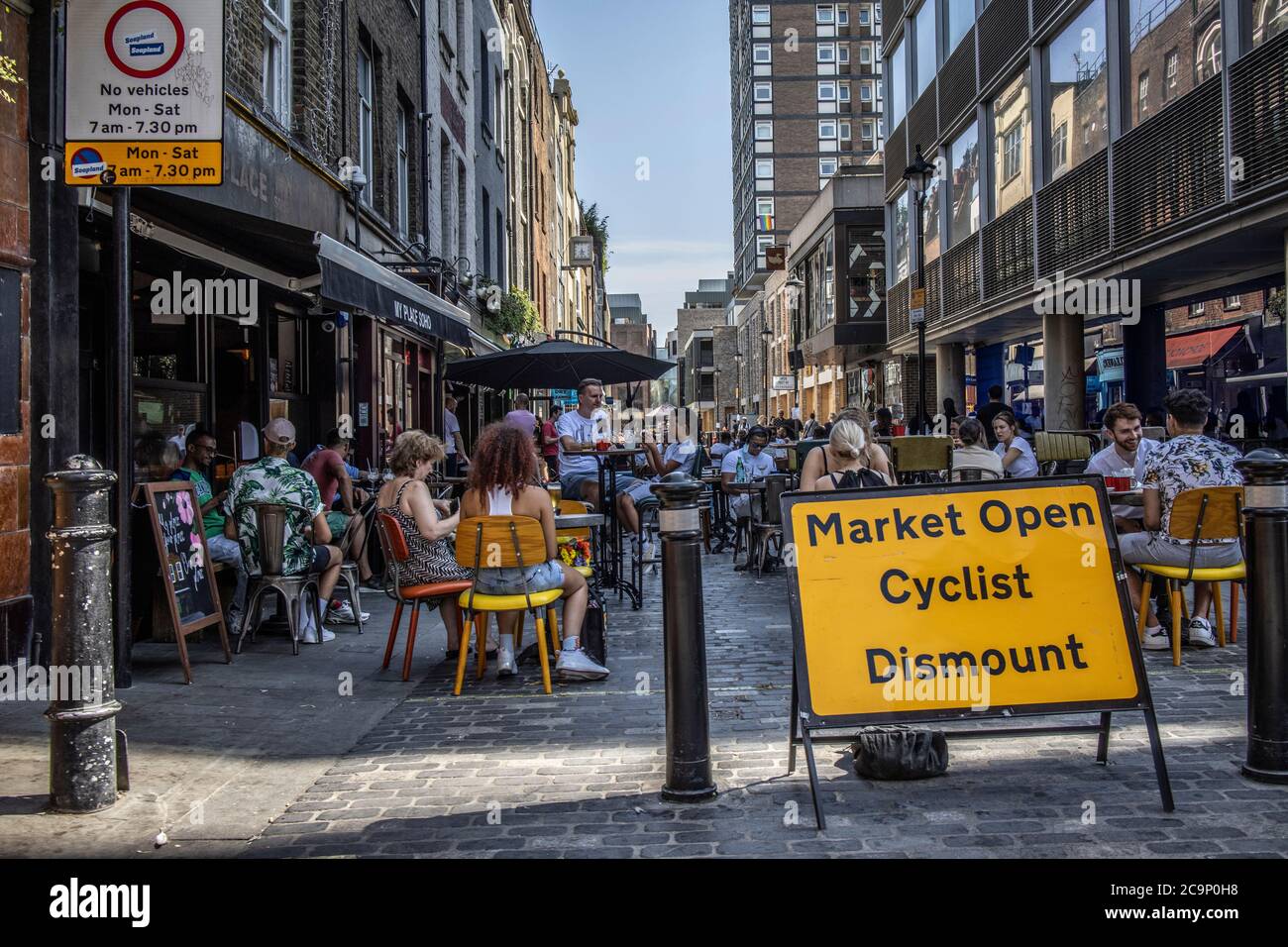 Die Leute sitzen draußen auf der Berwick Street und genießen die Café-Kultur an einem warmen Sommernachmittag, Post Coronavirus Lockdown, Soho, London, England, Großbritannien Stockfoto