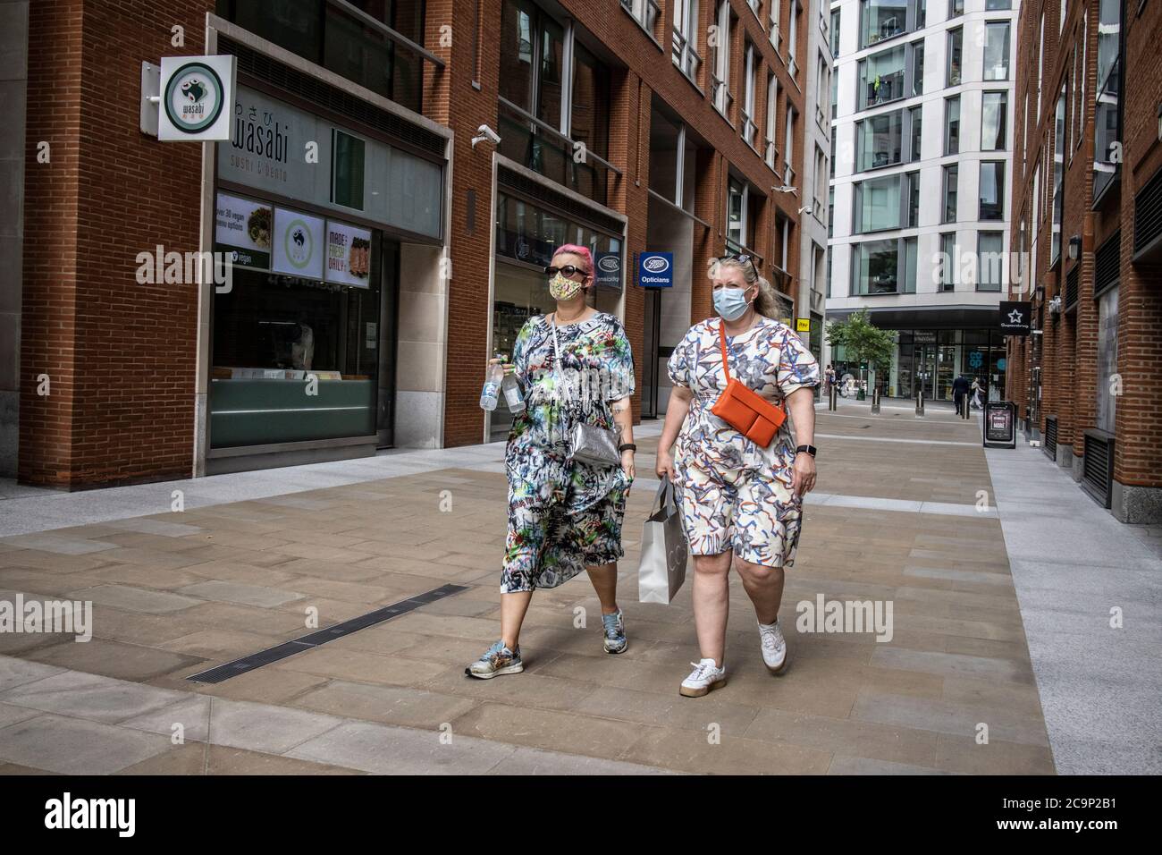 Menschen mit Gesichtsmasken kehren in die Straßen von Soho und dem West End von London zurück, da die neue Normalität dazu beiträgt, die Wirtschaft in Großbritannien wieder zu erholen. Stockfoto