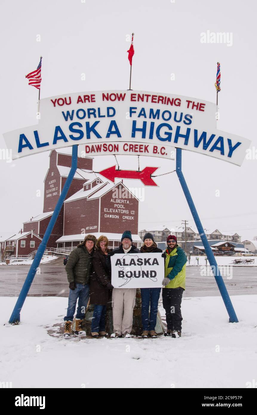 Eine Gruppe von Reisenden, die nach Alaska reisen, posieren am Anfang des Alaska Highway in Dawson Creek, British Columbia, Kanada Stockfoto
