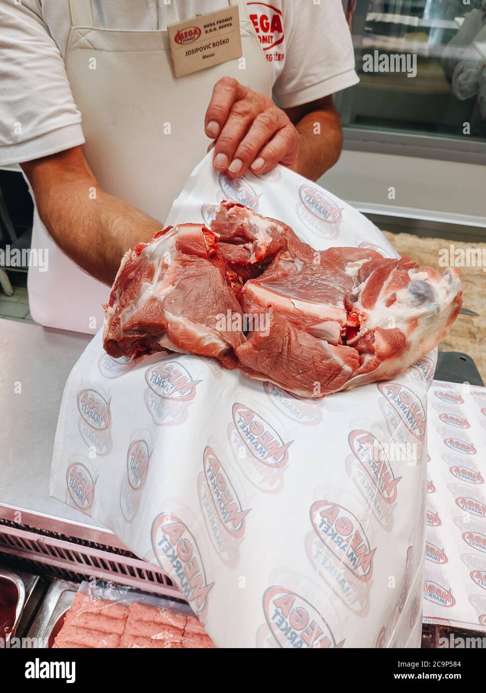Budva, Montenegro - 01. august 2020: Der Metzger im Laden zeigt Fleisch. Stockfoto