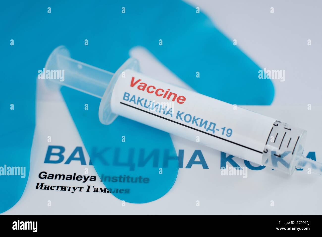 Spritze mit Covid-19-Impfstoff in kyrillischen Buchstaben und blauen Handschuhen im Hintergrund, Dänemark, 1. August 2020 Stockfoto
