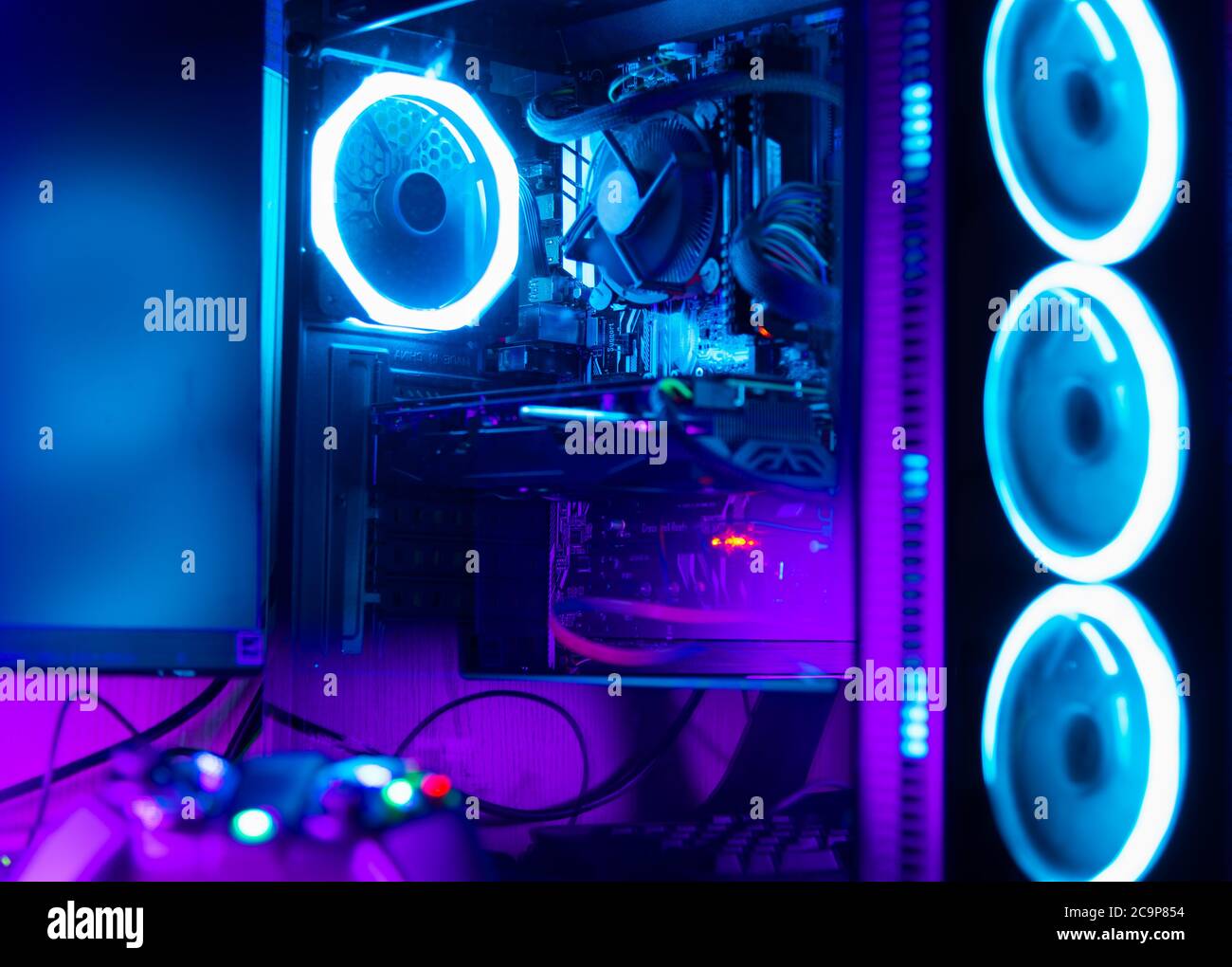 PC-Gehäuse aus Glas mit rgb-Beleuchtung und Schreibtisch mit Gamepad im  Vordergrund Stockfotografie - Alamy