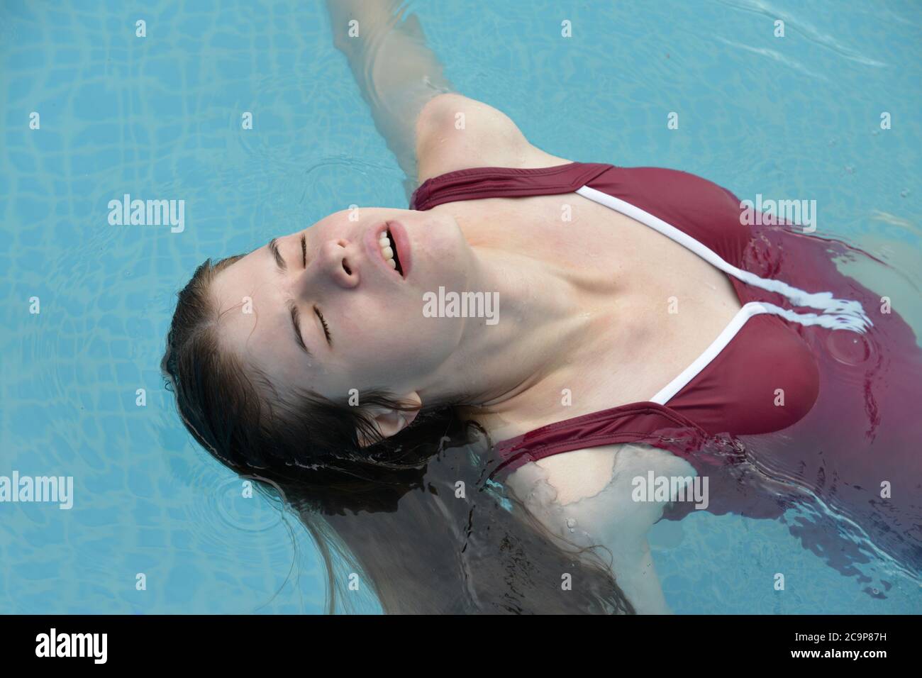 Junge Frau, die sich im Schwimmbad entspannt Stockfoto