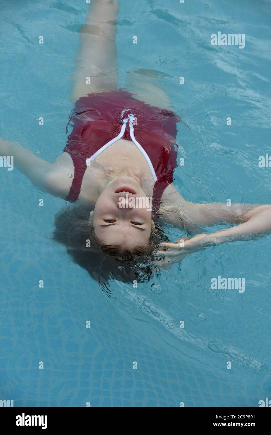 Junge Frau, die sich im Schwimmbad entspannt Stockfoto