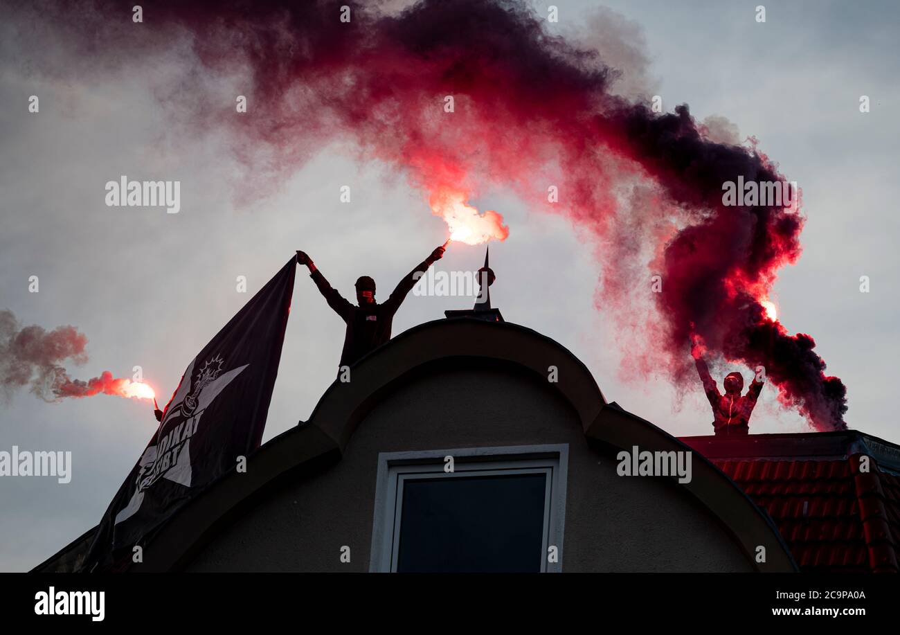 Berlin, Deutschland. August 2020. Bei einer Demonstration gegen die geplante Räumung des angesagten Pub-Syndikats Syndikat zünden Demonstranten Rauchpatronen auf einem Dach. Nach Angaben der Betreiber des Syndikats in Neuköllner Schillerkiez gibt es einen Räumungstermin am 7. August. Quelle: Fabian Sommer/dpa/Alamy Live News Stockfoto