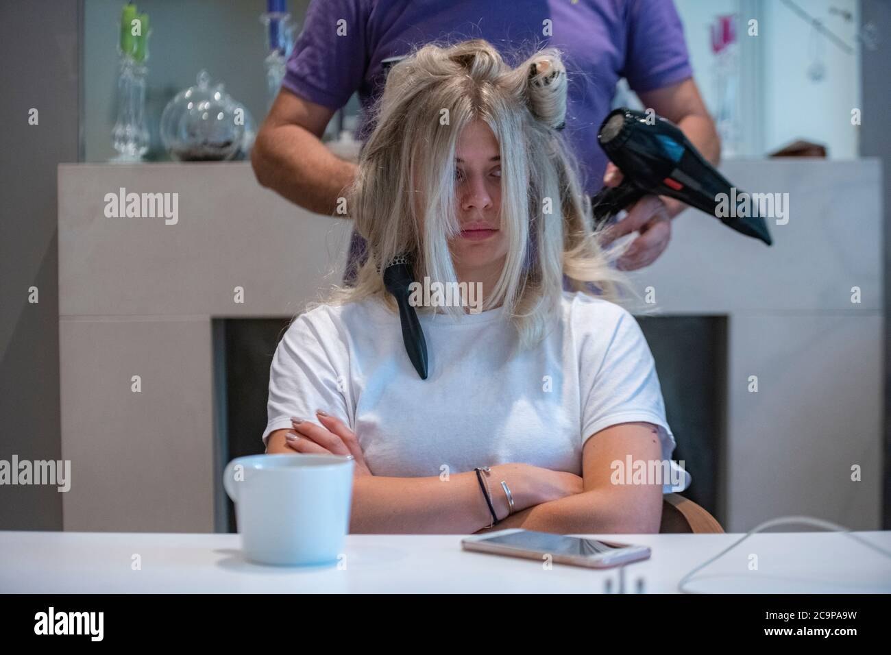 Ein Mädchen hat ihr Haar von ihrem Friseur zu Hause getrocknet Stockfoto