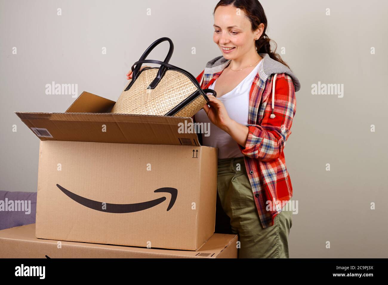 Juli 15, 2020. Bologna, Italien. Auspacken des Pakets Amazon. Eine Frau nimmt ihren Hut und ihre Tasche für den Sommerurlaub. Konzept des erfolgreichen Mailings, Service für Haus und Geschäft, Online-Shopping Stockfoto