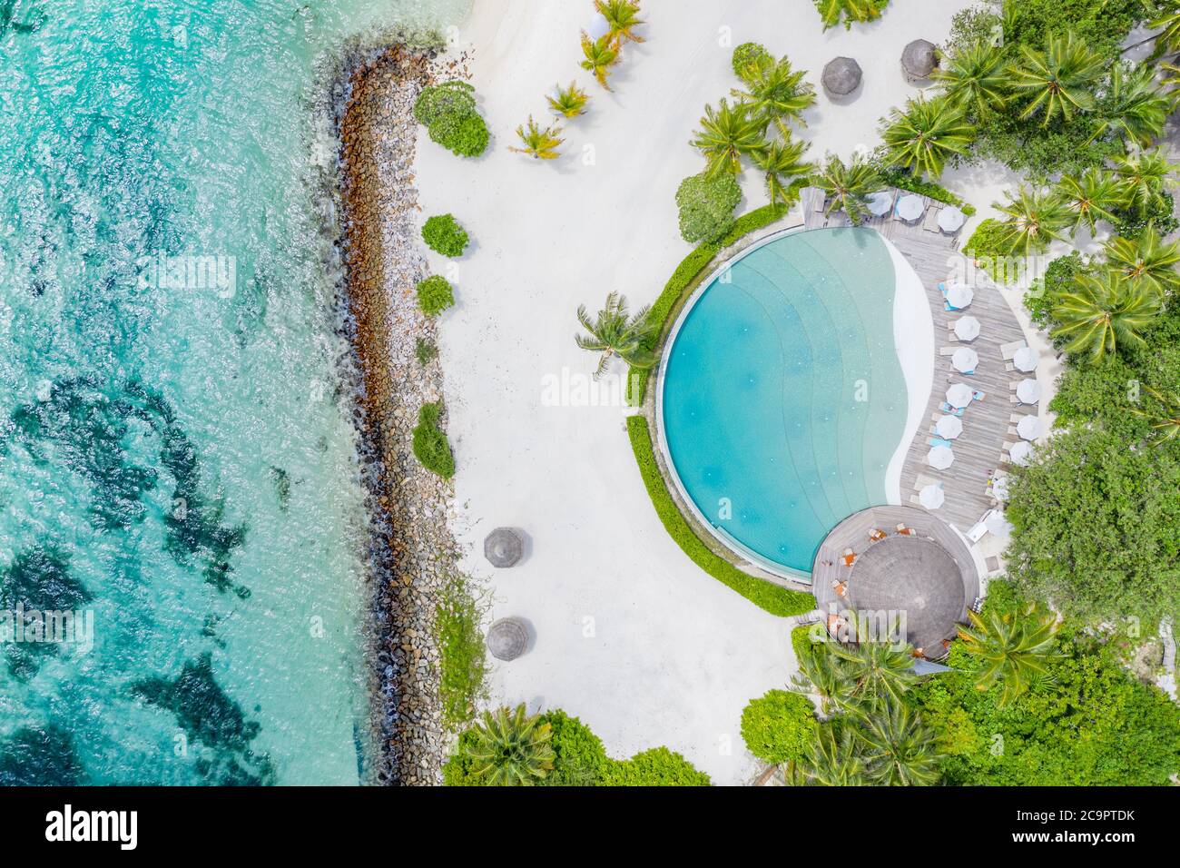 Drone am Strand, azurblauem Meer und Pool mit Palmen im Luxusresort der Malediven. Tropische Insel, exotische Luftlandschaft Stockfoto