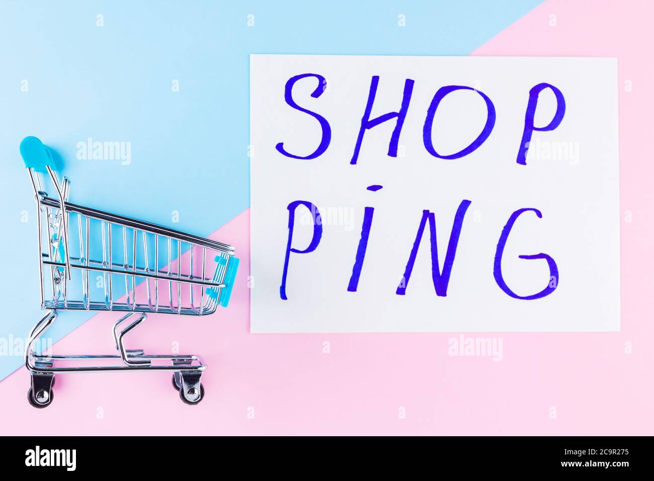 Warenkorb auf blauem Hintergrund. Shop Trolley im Supermarkt. Verkauf und Rabatt. Trend der Konsumgesellschaft. Konzept des Einkaufens. Draufsicht Stockfoto