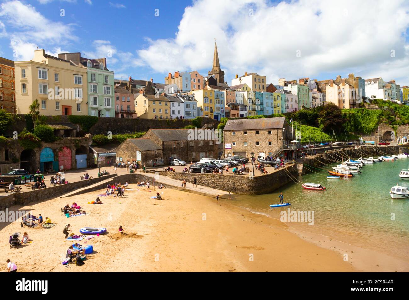 Malerischer Tenby Harbour bei Ebbe gefangen. Ein schöner sonniger Tag, der die bunten Häuser hervorhebt. Stockfoto