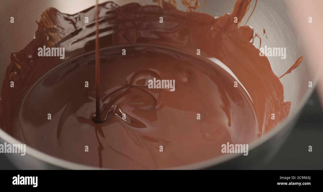 Mischen von dunkler geschmolzener Schokolade mit Löffel Nahaufnahme Stockfoto
