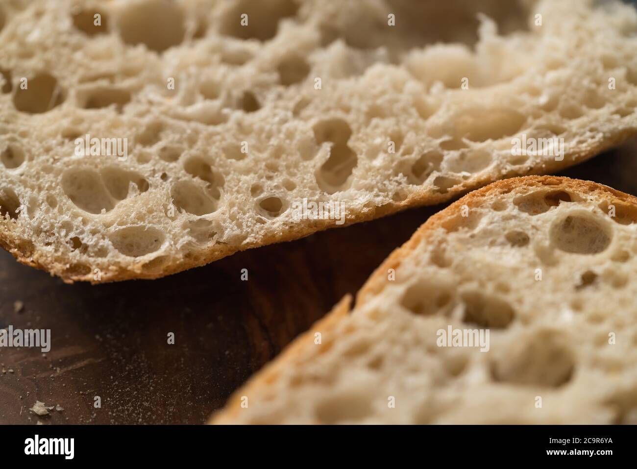 Ciabatta Brot in zwei Hälften geschnitten für Sandwich auf Olivenbrett Stockfoto