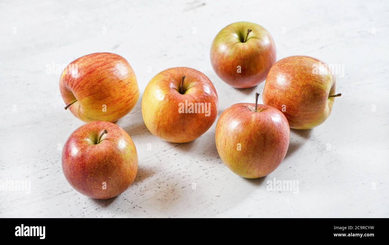 Rot / gelb glänzende Äpfel (kiku Sorte) auf weißem Arbeitsbrett Stockfoto