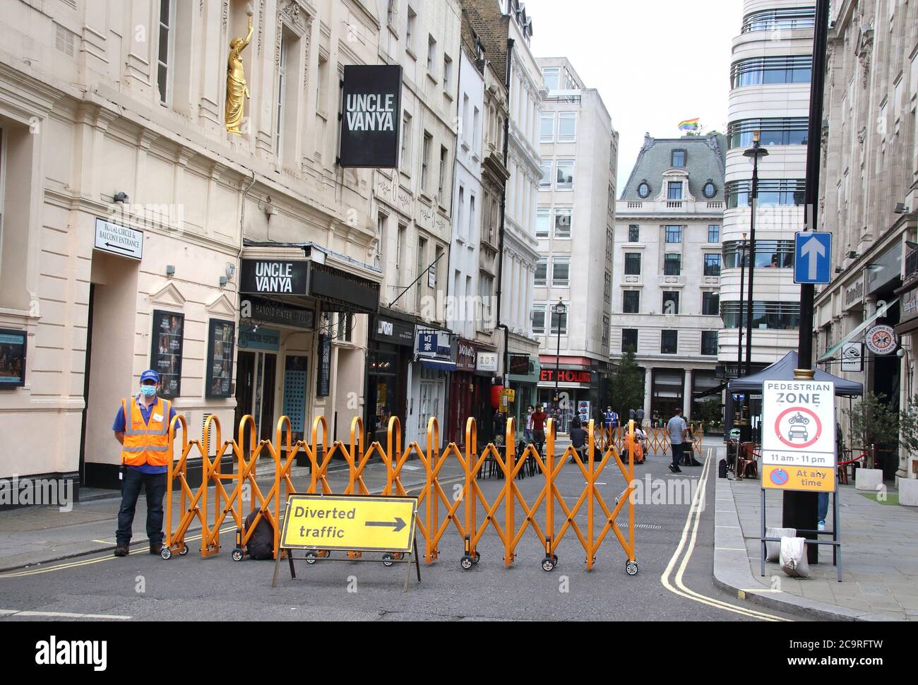 London, Großbritannien. August 2020. Ein Begleiter in Gesichtsmaske steht an einer Barriere, da die Panton Street im West End für den Verkehr gesperrt ist, damit Restaurants auf der Straße eingerichtet werden können.ein Großteil des Londoner West End soll in diesem Sommer an den Wochenenden in ein kontinentales Alfresco-Dining-Viertel verwandelt werden. Damit Restaurants und Bars dringend benötigten Platz im Freien für ihre Kunden. Kredit: SOPA Images Limited/Alamy Live Nachrichten Stockfoto