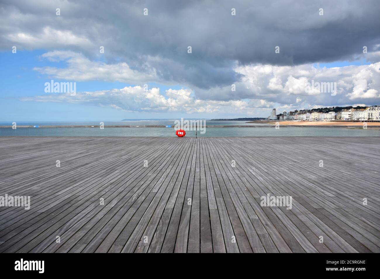 Eine einone unbeaufsichtigte Angelrute links auf der Promenade von Hastings Pier Blick nach Westen in Richtung St. Leonards, Bexhill, und Eastbourne, Sussex, England, Großbritannien. Stockfoto