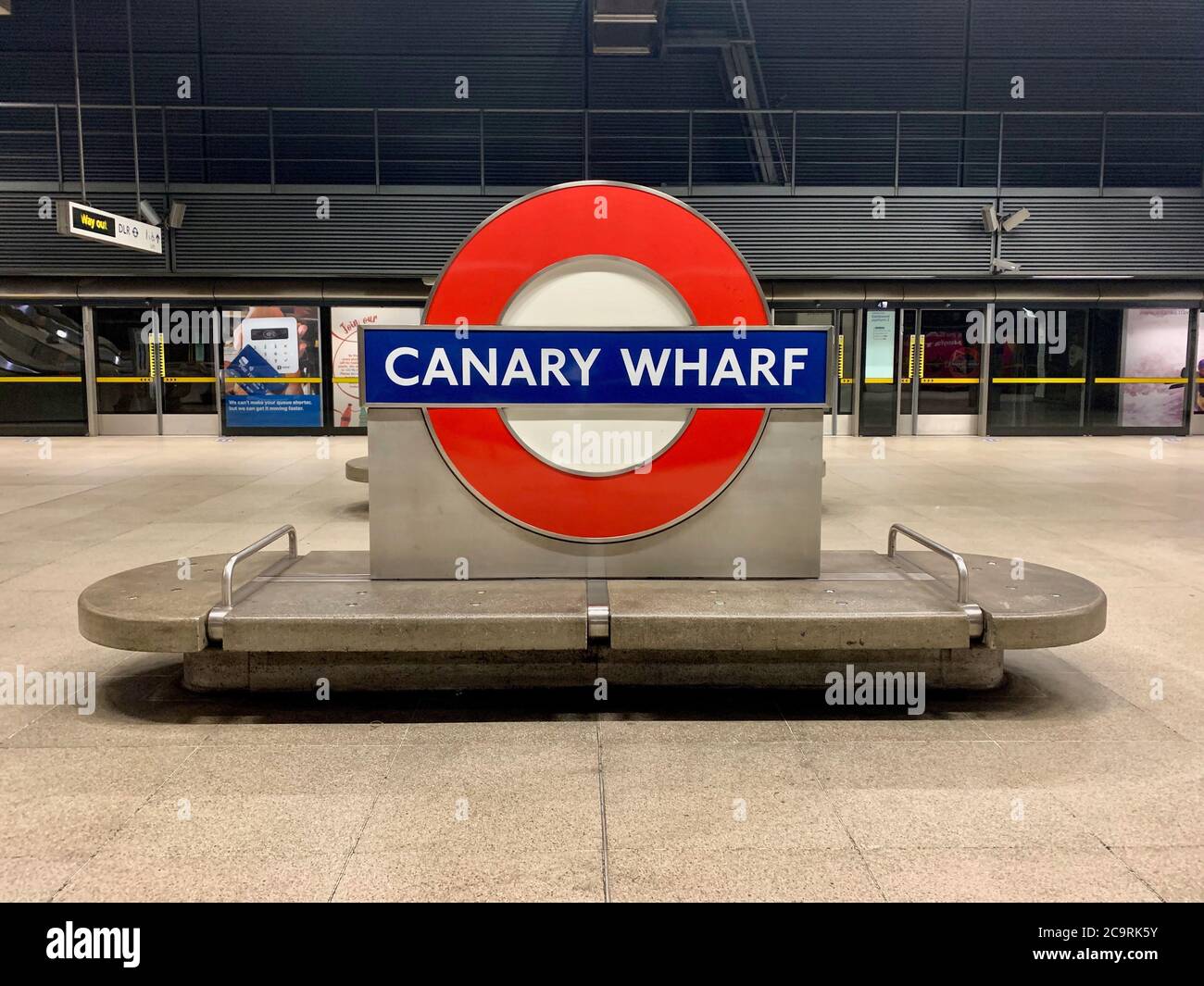 Canary Wharf U-Bahn. In der Station auf dem Bahnsteig aufgenommen. Die Canary Wharf unterirdisch Schild und Bank auf einer leeren Plattform. Stockfoto