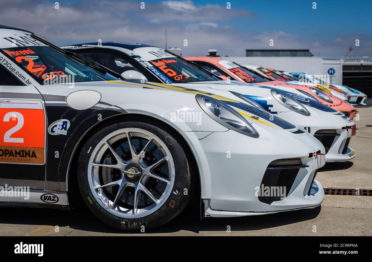 Mehrere Porsche-Rennwagen stehen auf der Estoril Racetrack in Portugal an und warten darauf, für den Porsche Império GT3 Cup vorbereitet zu sein. Stockfoto