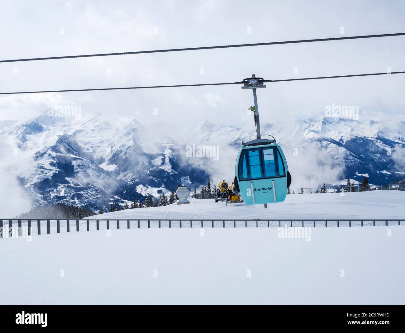 Zell am See, ÖSTERREICH, 14. März 2019: Blauer Seilbahnlift auf dem Gipfel der Smittenhöhe im Skigebiet Kaprun mit schneebedeckten Gipfeln. Stockfoto