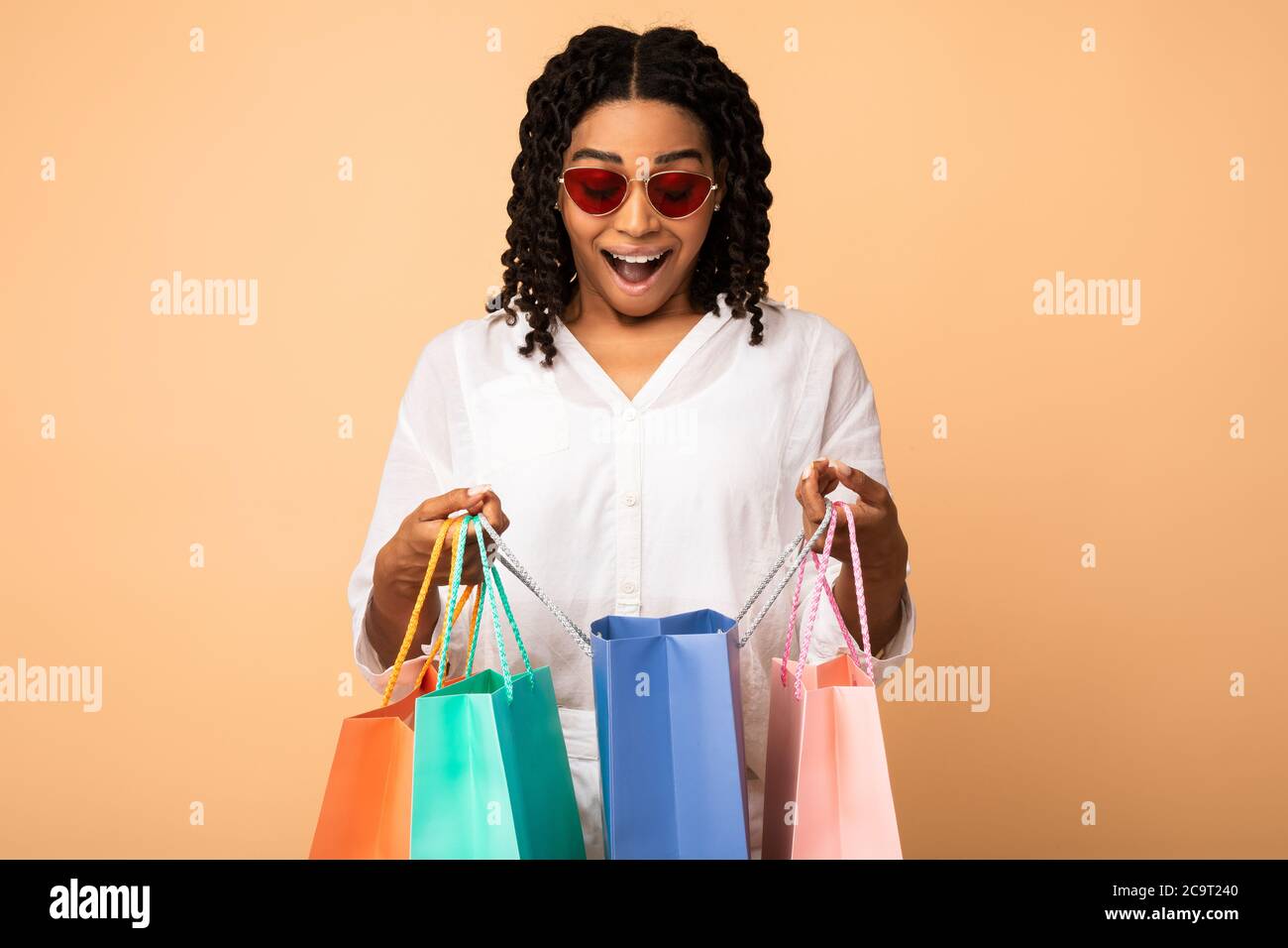 Fröhliche Afrikanische Frau Holding Shopper Taschen Stehen Auf Beige Hintergrund Stockfoto