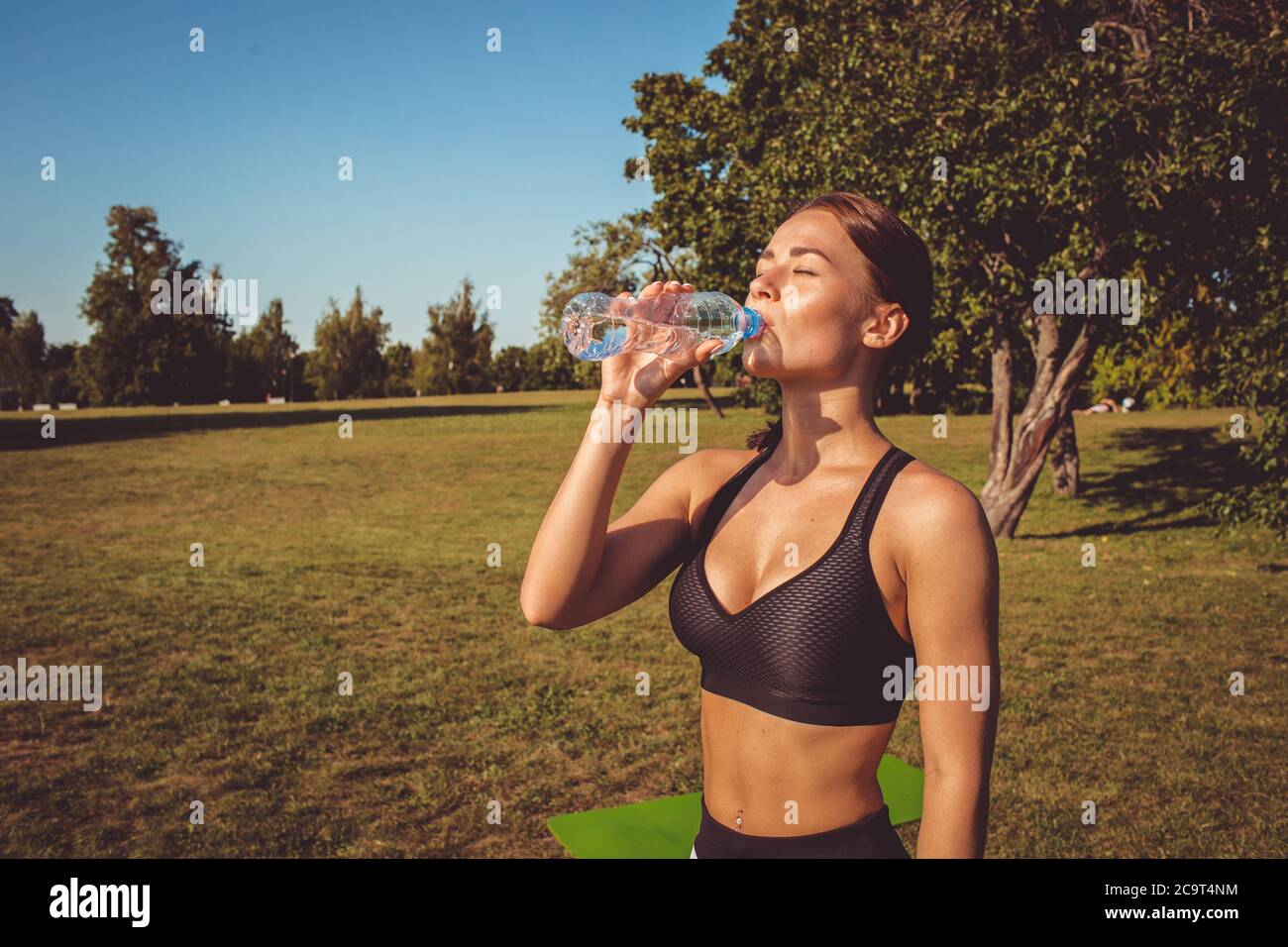 Schönes Mädchen trinkt Wasser. Nach dem Sport und Yoga Stockfoto