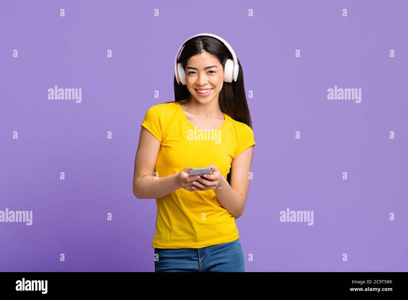 Musik-App Fröhliche Asiatische Mädchen Mit Smartphone Und Kopfhörer Hören Lieblingslieder Stockfoto