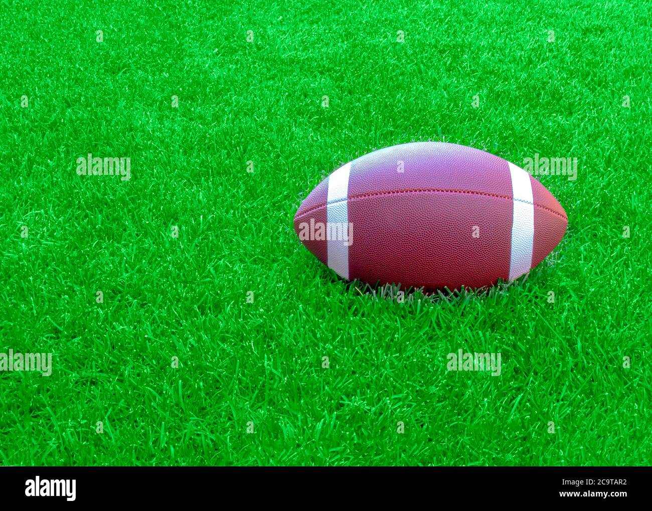 Ein amerikanischer Fußball auf einem grünen Rasen während des Tages. Stockfoto