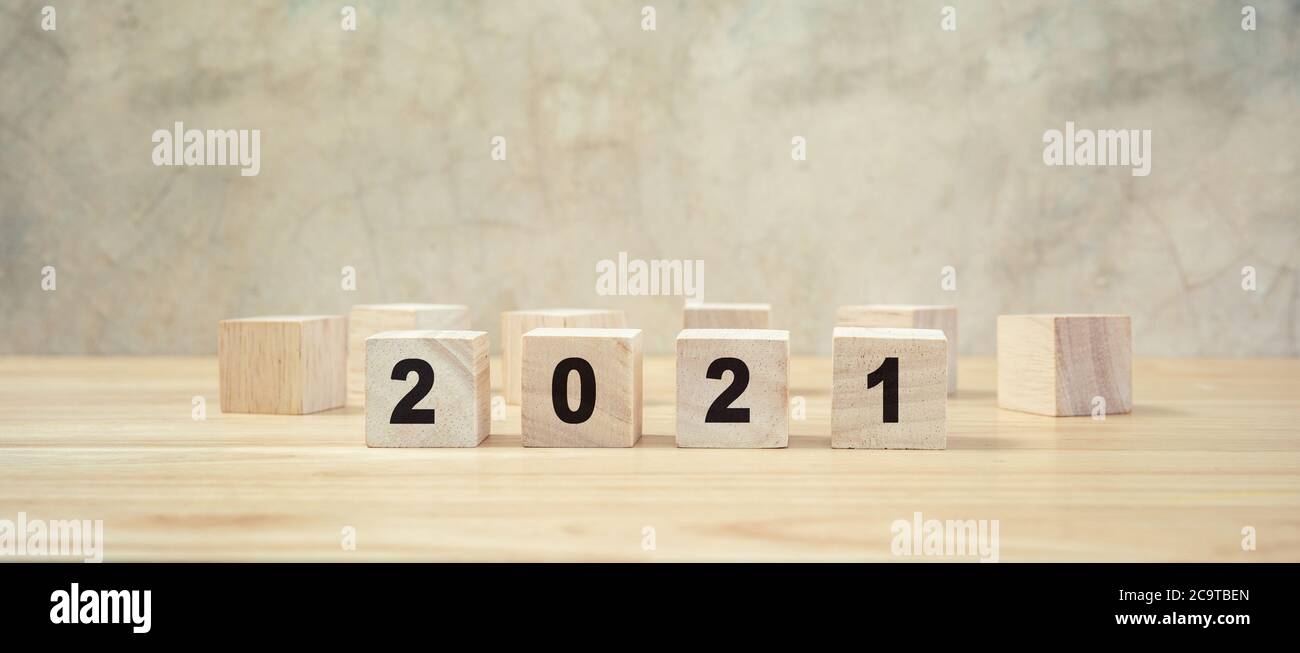 2021 frohes neues Jahr auf Holzblock auf Holztisch und grauem Hintergrund. Neujahr Konzept. Stockfoto