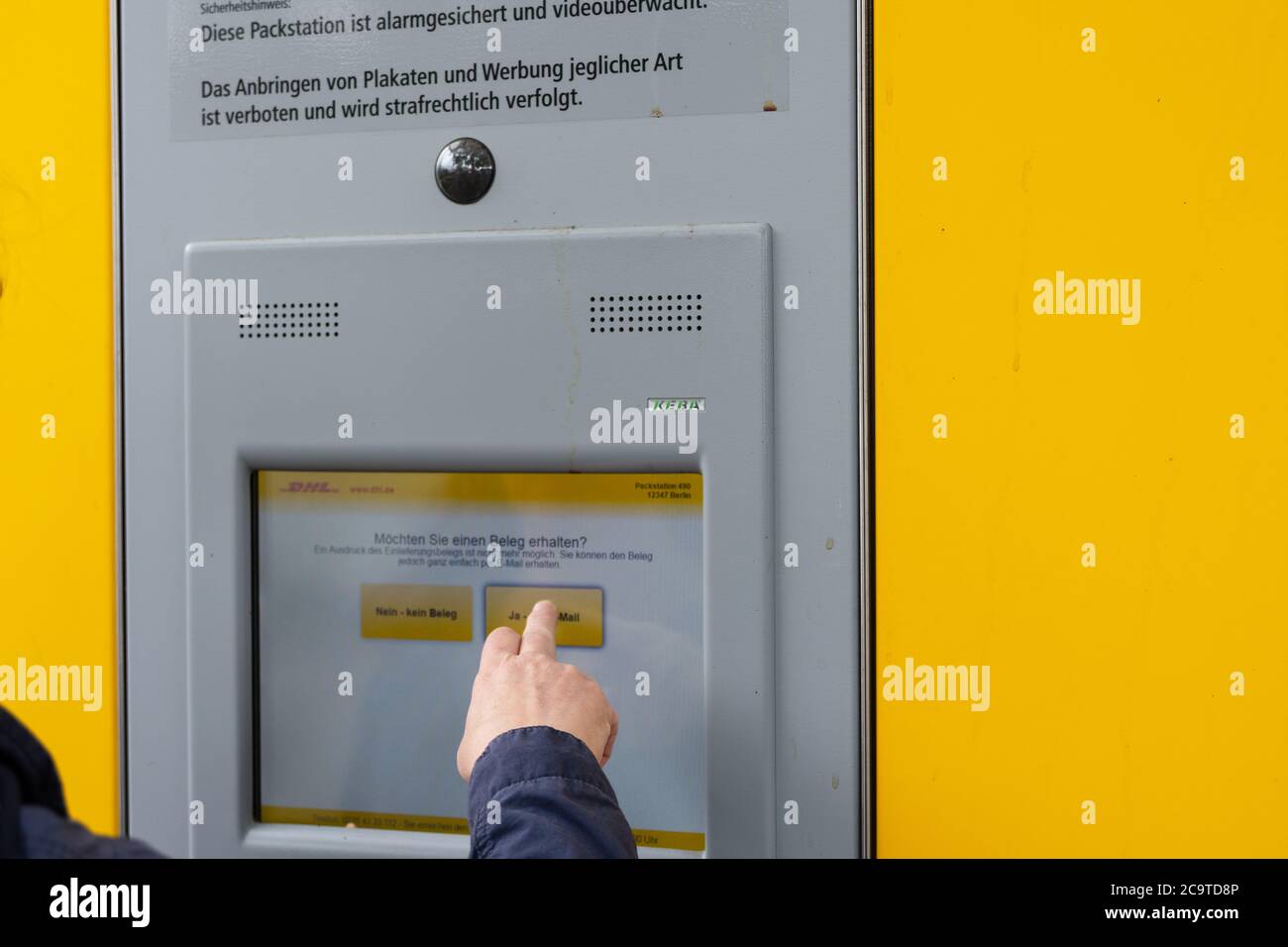 DHL Packstation, wo Kunden ihre Bestellung selbst abholen und auch Pakete  versenden können. Hier erfahren Sie, wie ein Kunde den Vorgang abschließt  Stockfotografie - Alamy