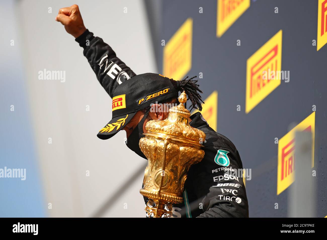 Mercedes-Brite Lewis Hamilton zeigt sich auf dem Siegerpodest, nachdem er am 2. August 2020 auf der Silverstone-Rennstrecke in Silverstone, Zentralengland, den Grand Prix der Formel 1 gewonnen hatte. - Lewis Hamilton überlebte ein dramatisches Finale, um den britischen Grand Prix am Sonntag zu gewinnen, nur über die Linie auf drei Reifen, um einen schnellen schließenden Max Verstappen auf Red Bull zu schlagen Der Titelverteidiger gewann den siebten britischen Grand Prix, als Ferarri's Charles Leclerc auf Rang drei und Daniel Ricciardo von Renault auf Rang vier kam. (Foto von Bryn Lennon / POOL / AFP) Stockfoto