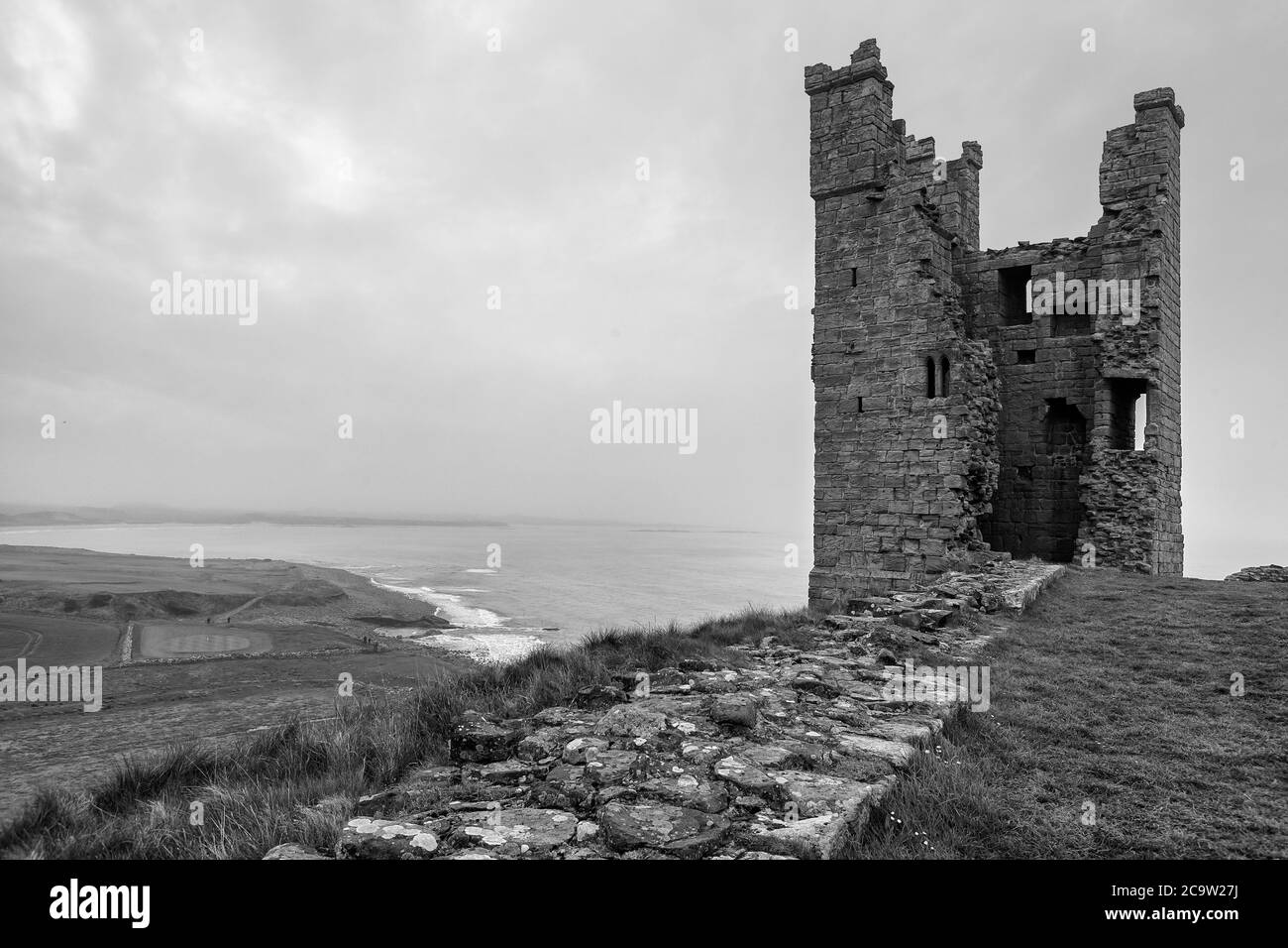 Lilburn Tower, Teil der Ruinen von Dunstanburgh Castle, Northumberland Coast, England, UK, an einem trüben, bewölkten Tag. Schwarz-Weiß-Version Stockfoto