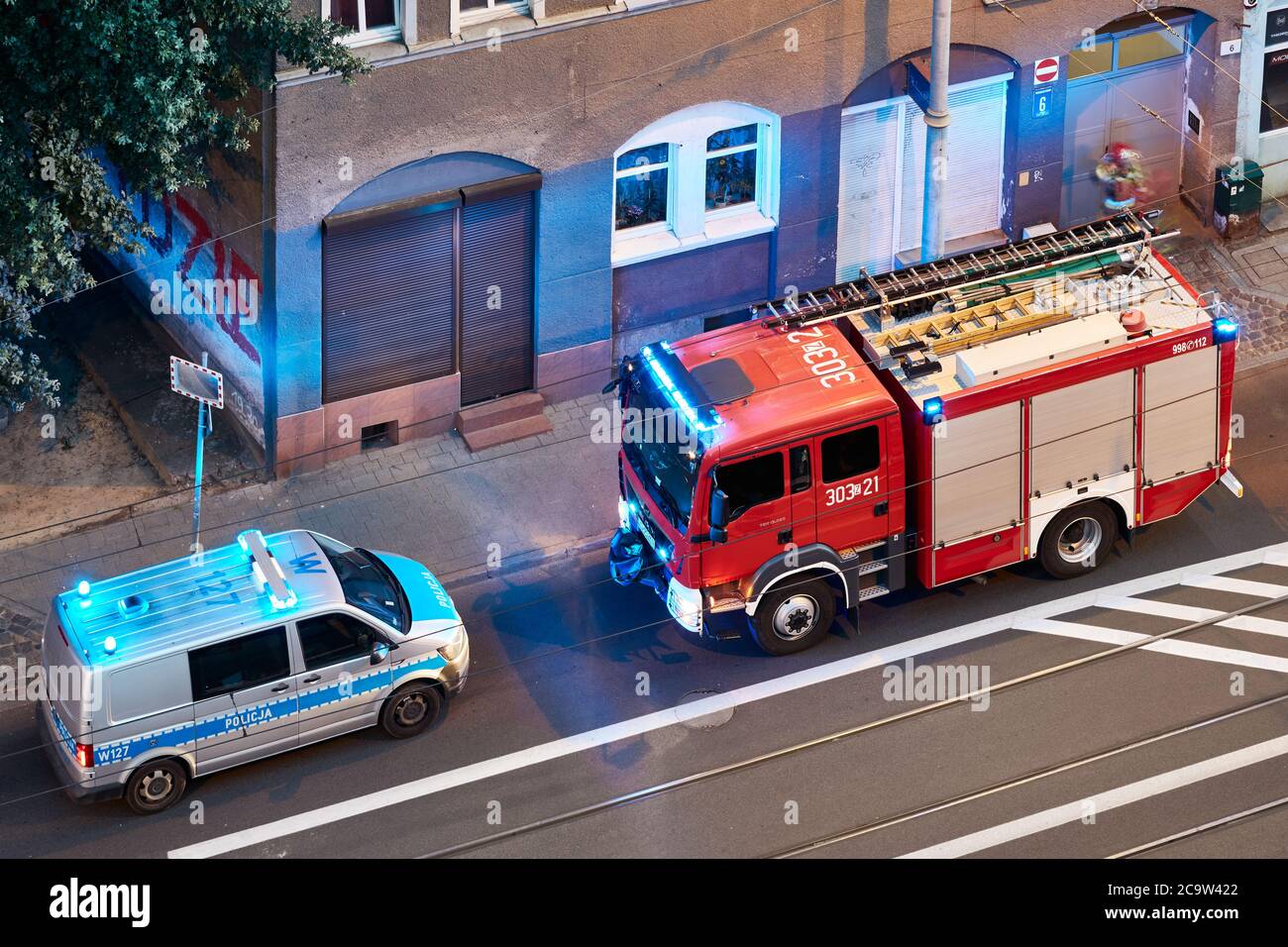 Szczecin, Polen - 01. August 2020: Feuerwehrauto und Polizeiwagen reagieren auf einen Notfall im Mietshaus in der Niemierzynska Straße in der Abenddämmerung. Stockfoto
