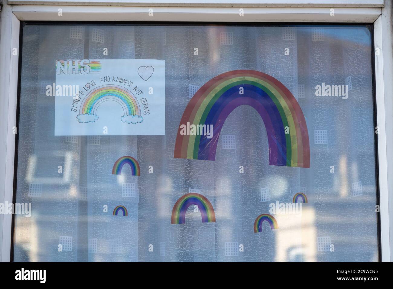 Regenbögen, die von Kindern während der Coronavirus-Pandemie oder Covid-19 in die Fenster ihres Hauses gezogen wurden Stockfoto