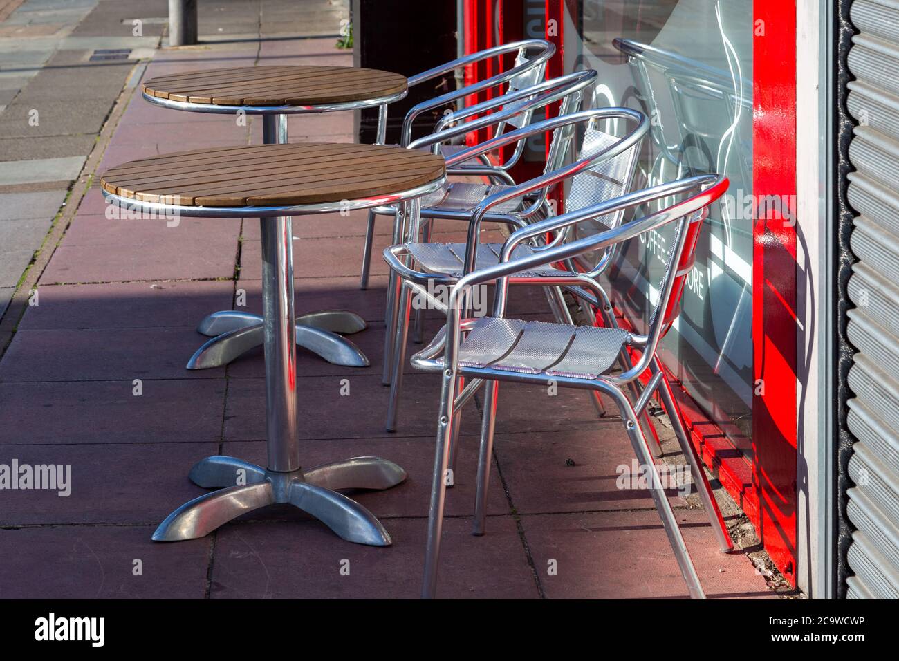 Leere Tische und Stühle vor einem Restaurant, das normalerweise voll ist Kunden essen Stockfoto