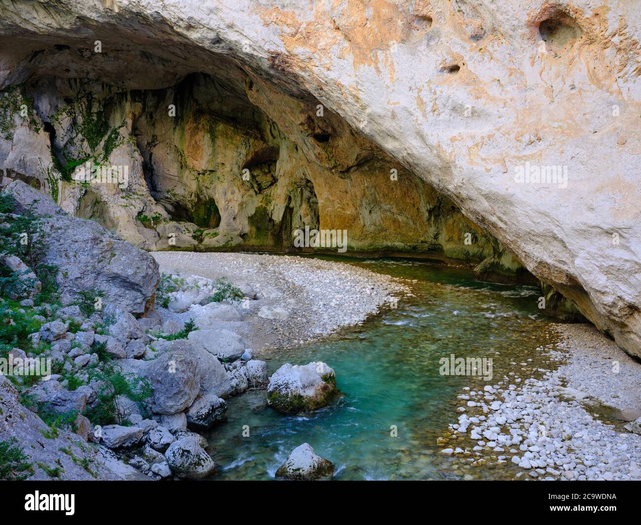 VERDON FLUSS IN EINE GROSSE FLACHE HÖHLE AM BODEN EINER 330 METER HOHEN KALKSTEINKLIPPE. La Baume-aux-Pigeons, La Palud-sur-Verdon, Frankreich. Stockfoto