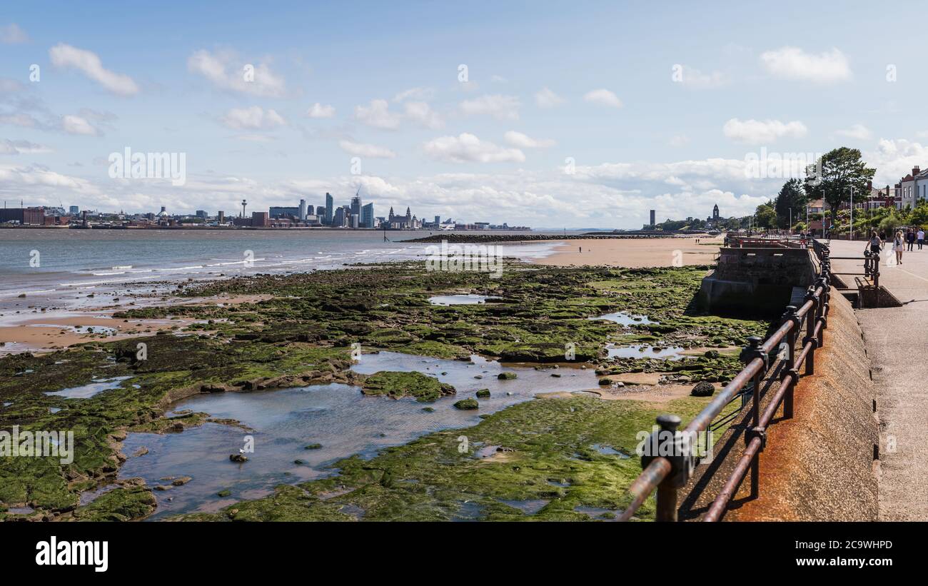 Skyline von Liverpool über den Felsenpools bei Ebbe von der Promenade in New Brighton im August 2020 gesehen. Stockfoto