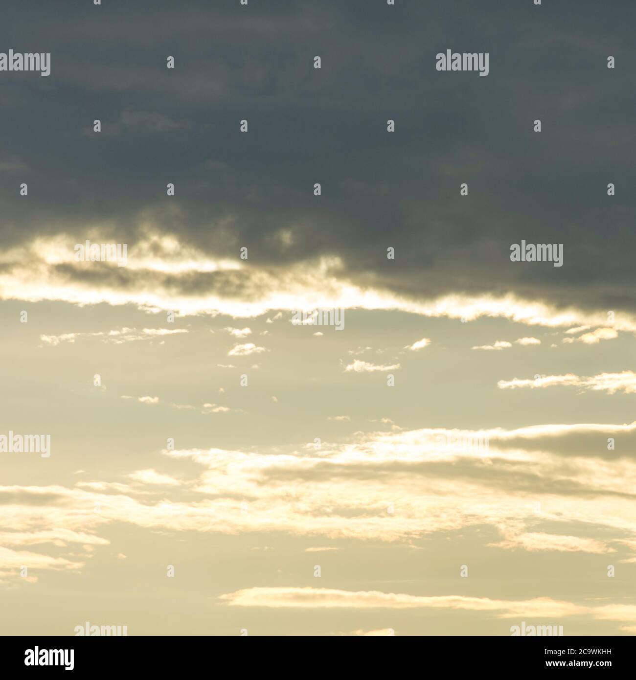 Trübe Stimmung über dem Gardasee in Italien. Dunkle Wolken gegen den hellen Himmel. Ein Vogel fliegt einsam über den Himmel. Wolkenfetzen breiteten sich aus. Stockfoto