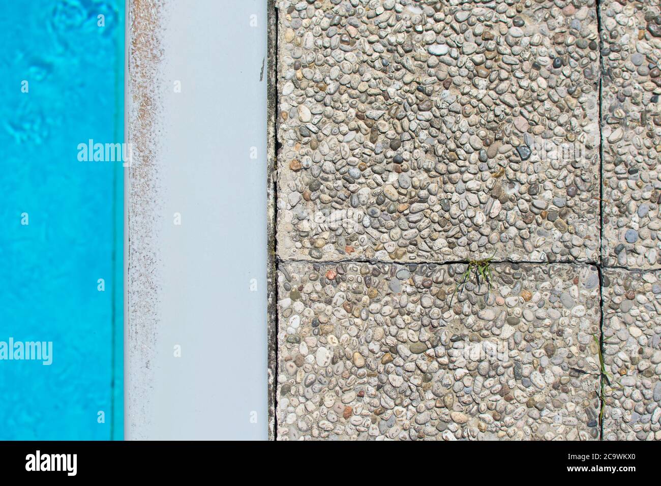 Verschiedene Materialien als Textur. Blauer Pool, weißer Betonumrandung, graue Steinplatten. Stockfoto