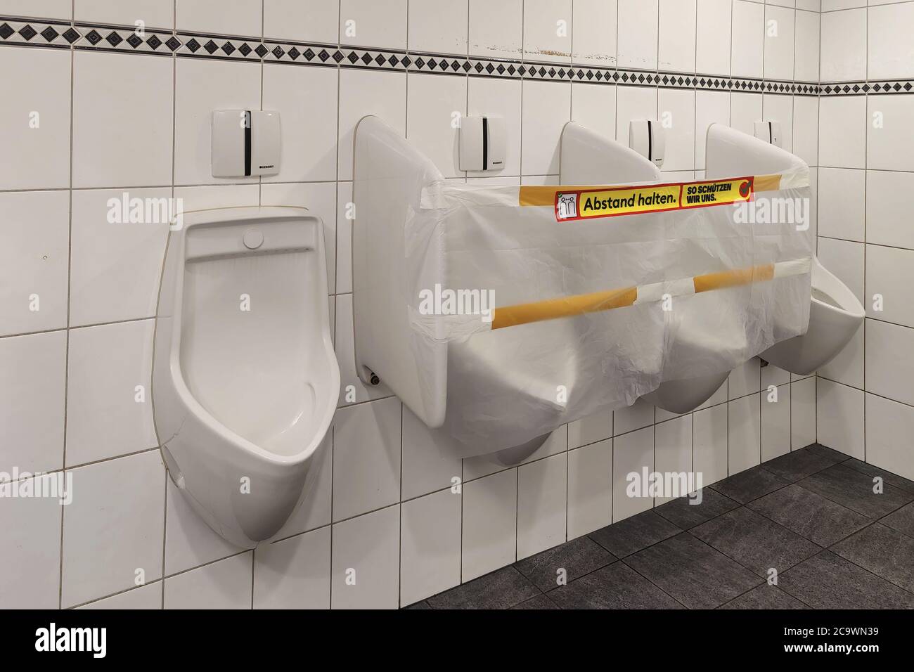 Dietikon, Zürich - Schweiz - 26. Mai 2020: Die beiden mittleren Urinale sind verschlossen und mit Kunststoff verklebt, um den Abstand in der öffentlichen Toilette zu gewährleisten Stockfoto