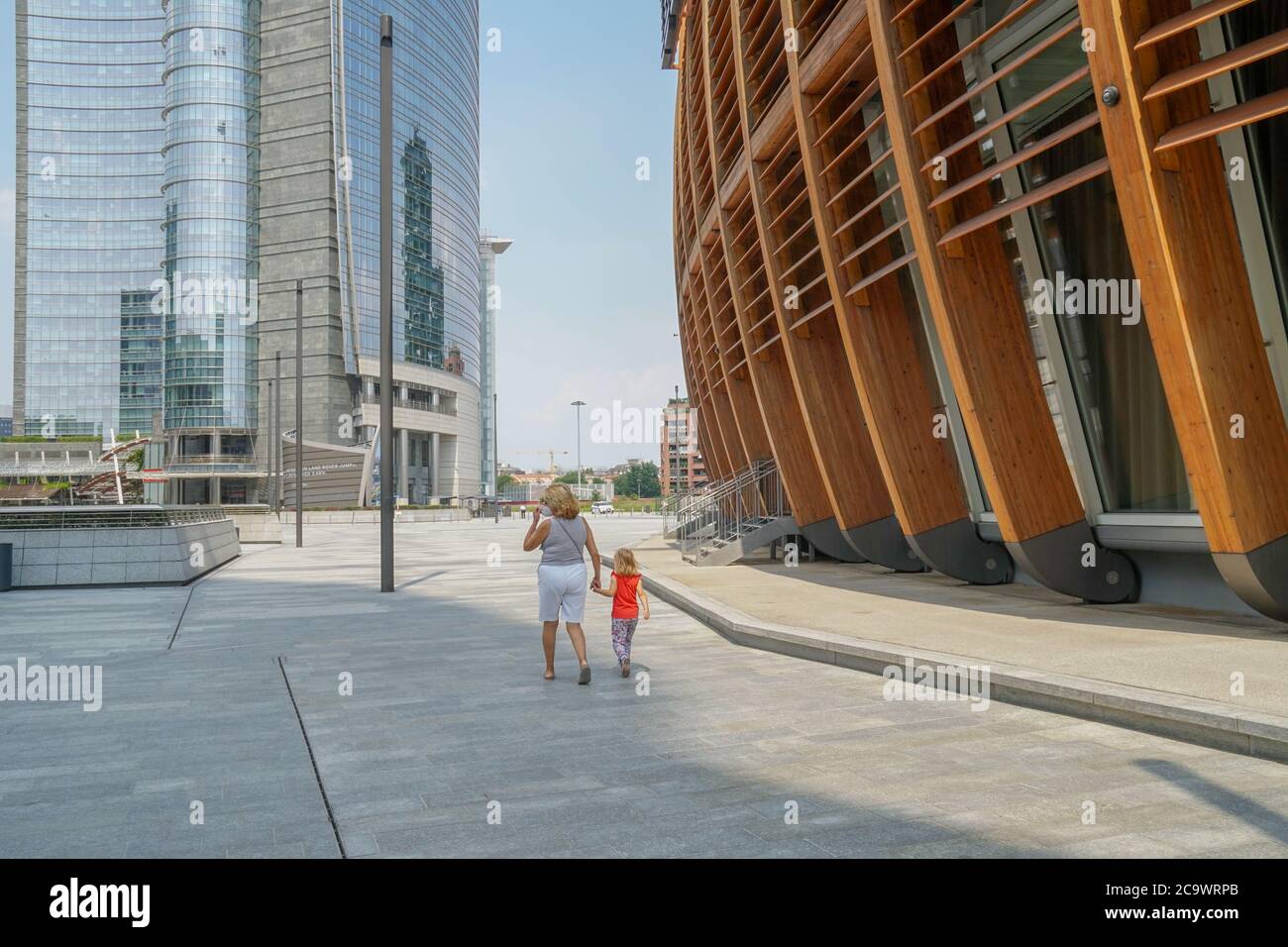 Mailand 07/15/2020: Großmutter und Enkelin gehen mit den Händen in einem leeren Stadtteil Porta Nuova Stockfoto