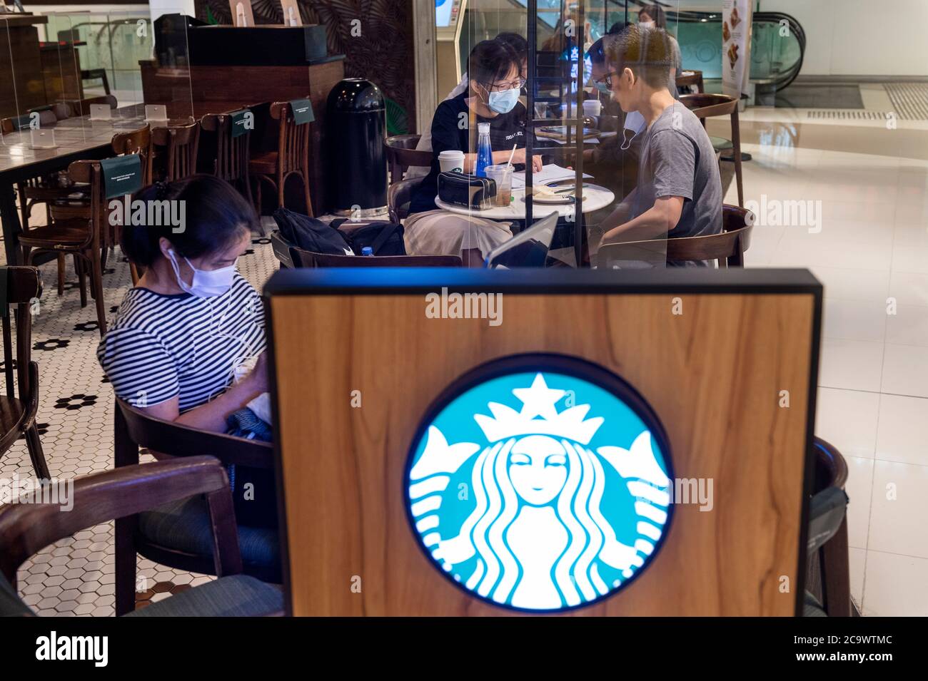 Gäste, die in der amerikanischen multinationalen Kette, im Starbucks Coffee Store und im Logo in Hongkong sitzen. Stockfoto