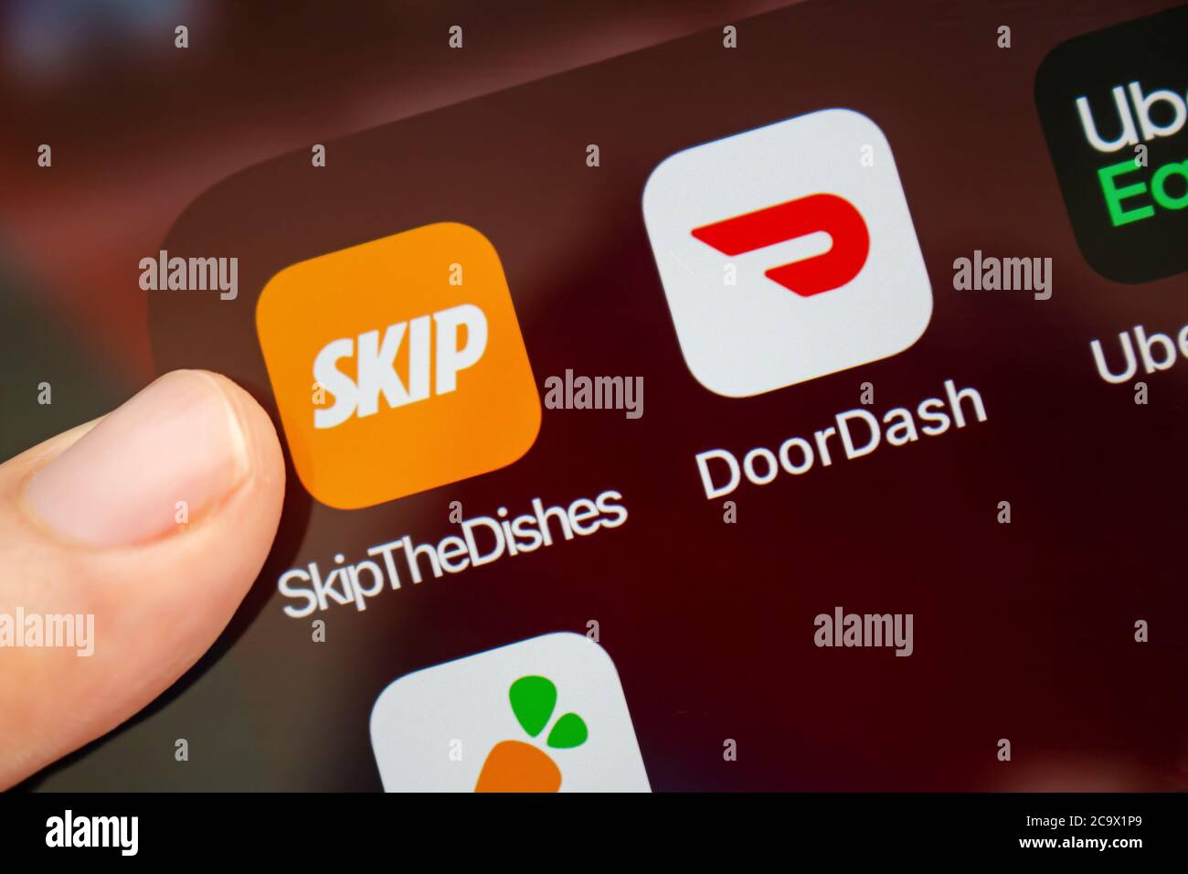 Calgary, Alberta, Kanada. August 2020. Eine Person, die die App „Skip the Dishes“ mit ihrem neuen Logo verwenden wird. Stockfoto