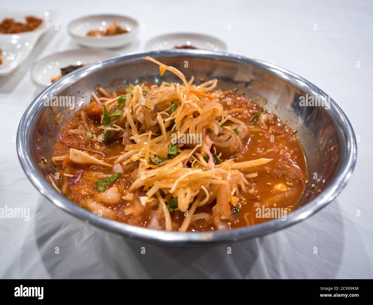 Mulhoe, kalte rohe Fischsuppe in Gangneung, Gangwon, Südkorea. Eisiges Bad mit roter Paprikabrühe. Roher Fisch mit Gemüse und roter Chili-Paste-Sauce. Stockfoto